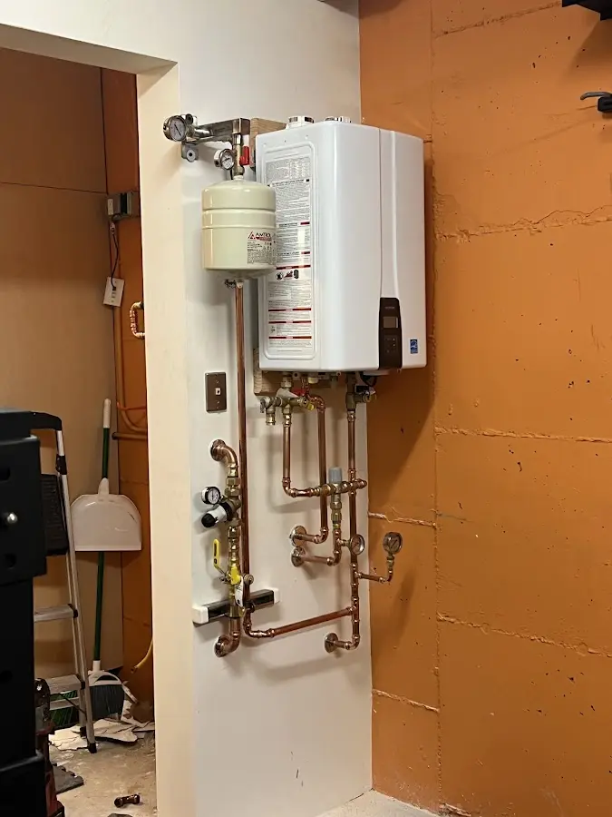 Plumbing technician inspecting water heater connections in Rigby